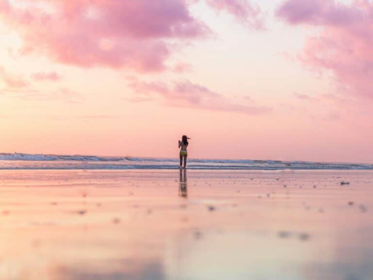 rouw die in de vroege ochtend op het strand wandelt bij zonsopgang